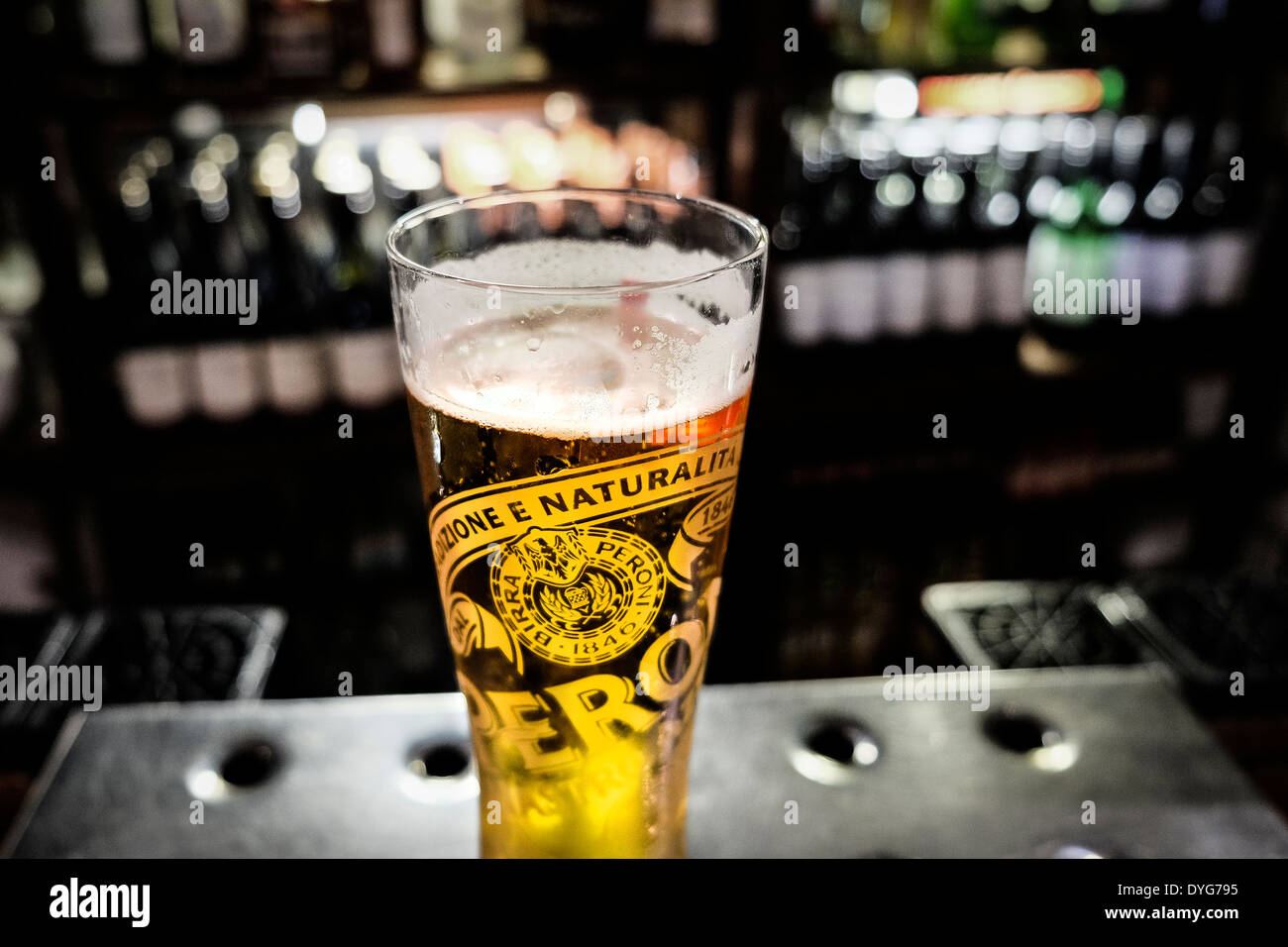 A partially consumed pint of Peroni beer on a bar in a pub. Stock Photo