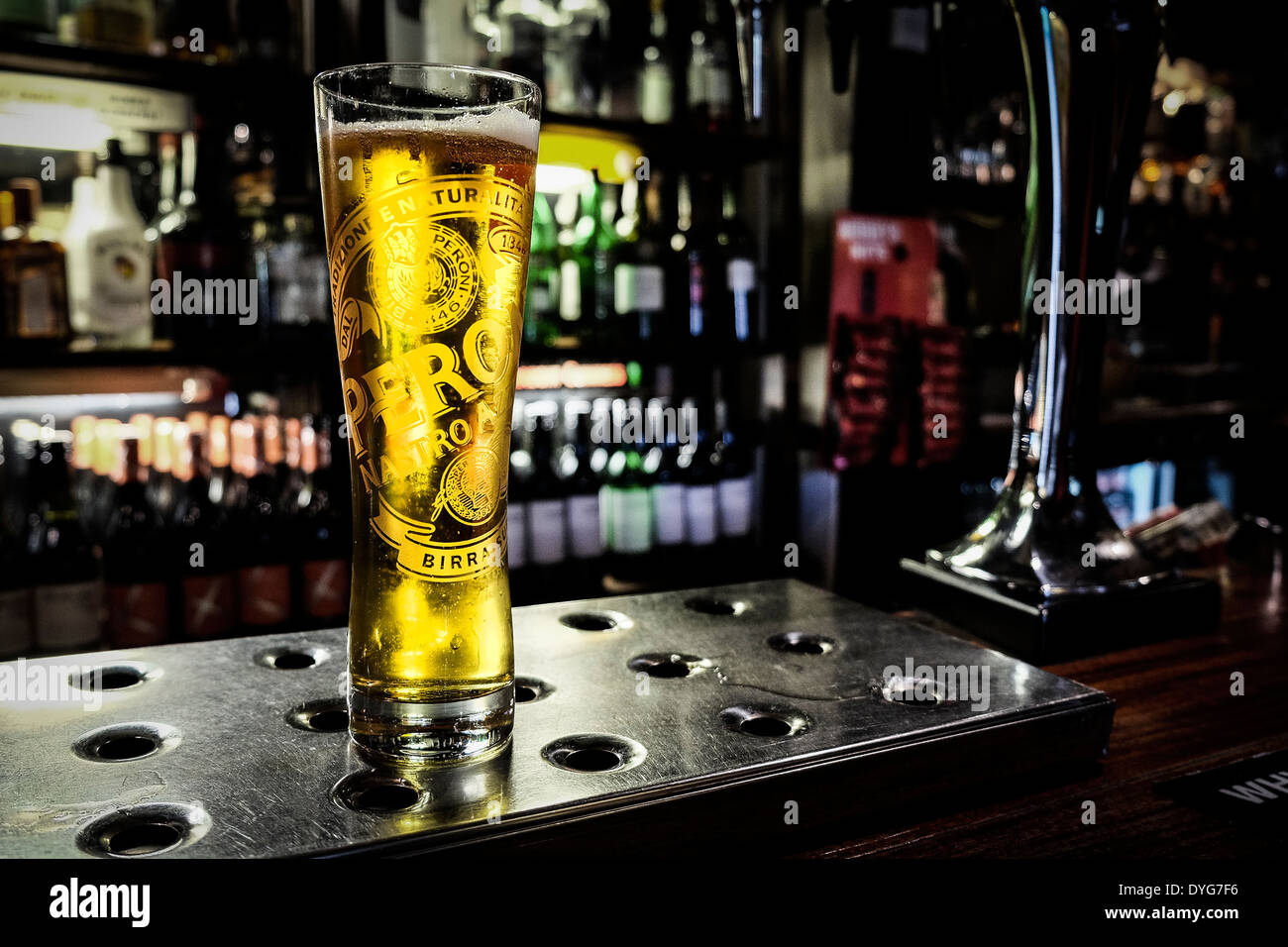 A partially consumed pint of Peroni beer on a bar in a pub. Stock Photo