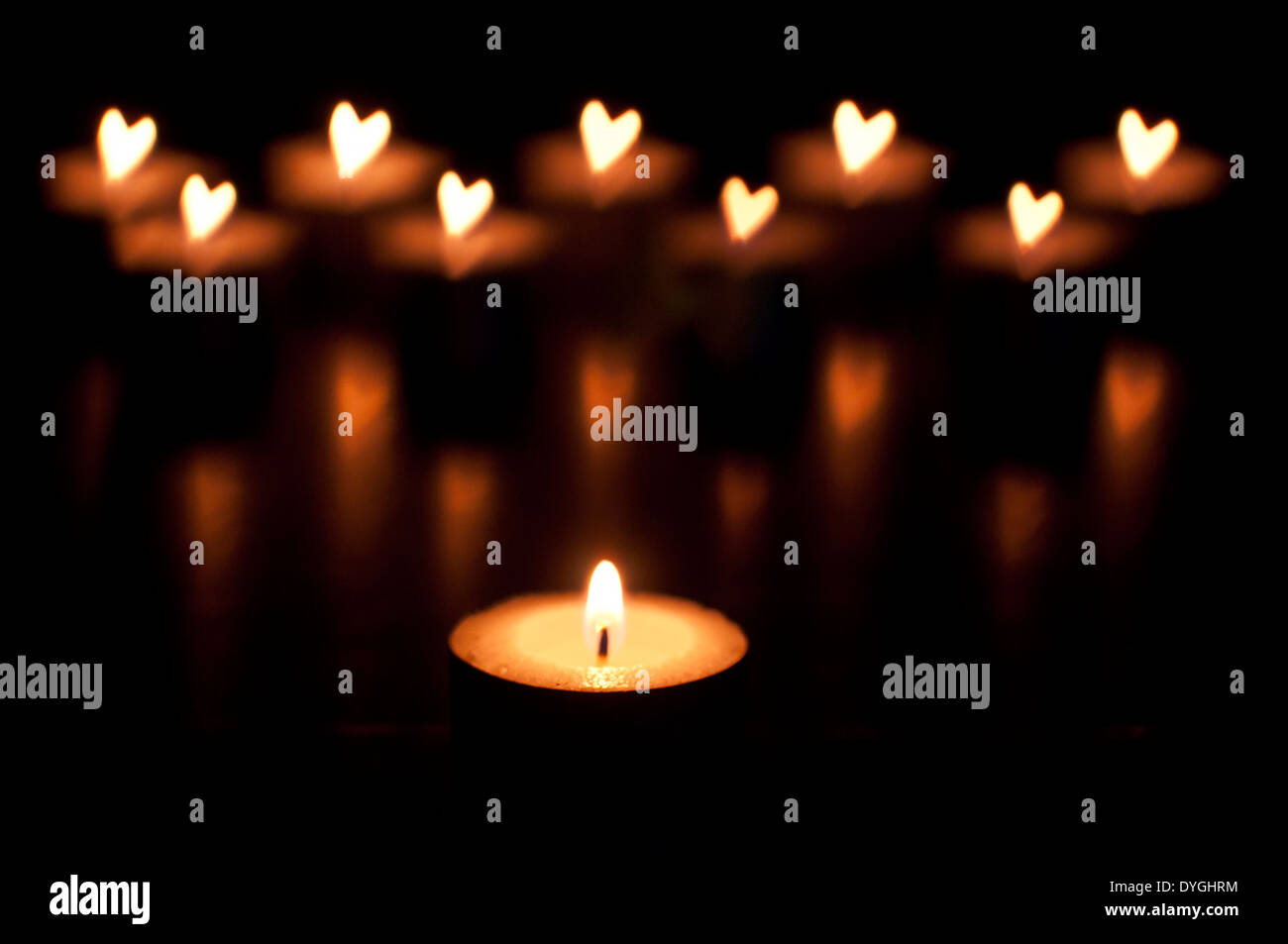 candles with out of focus flames in the shape of love hearts, valentines day. Be Kind. Love Stock Photo