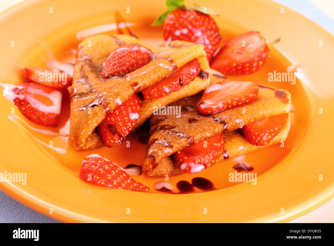 Two pancakes hearts with strawberry, chocolate, sugar milk, close up Stock Photo