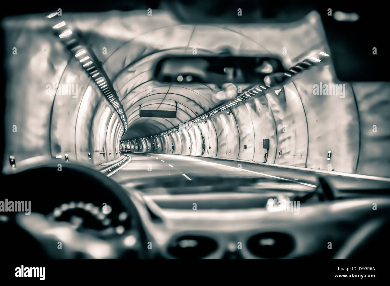 Abstract toned photo of a car driving through highway tunnel. Stock Photo