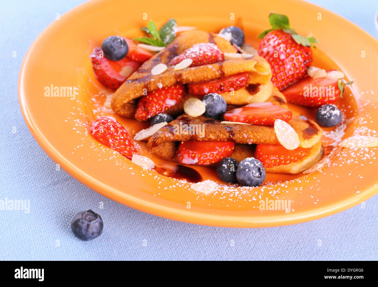 Two pancakes hearts with strawberry, blueberries and almond slivers Stock Photo