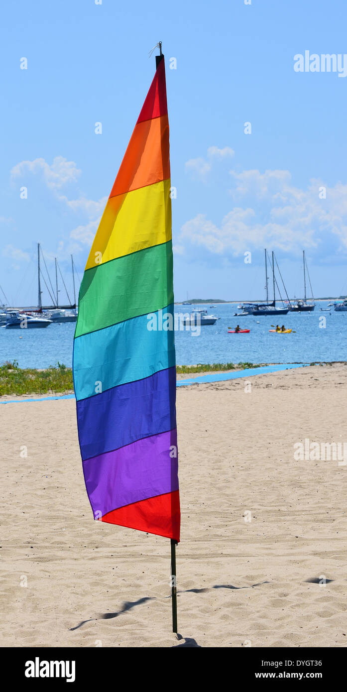 A gay pride feather flag against the background of a marina in Provincetown, Massachusetts Stock Photo