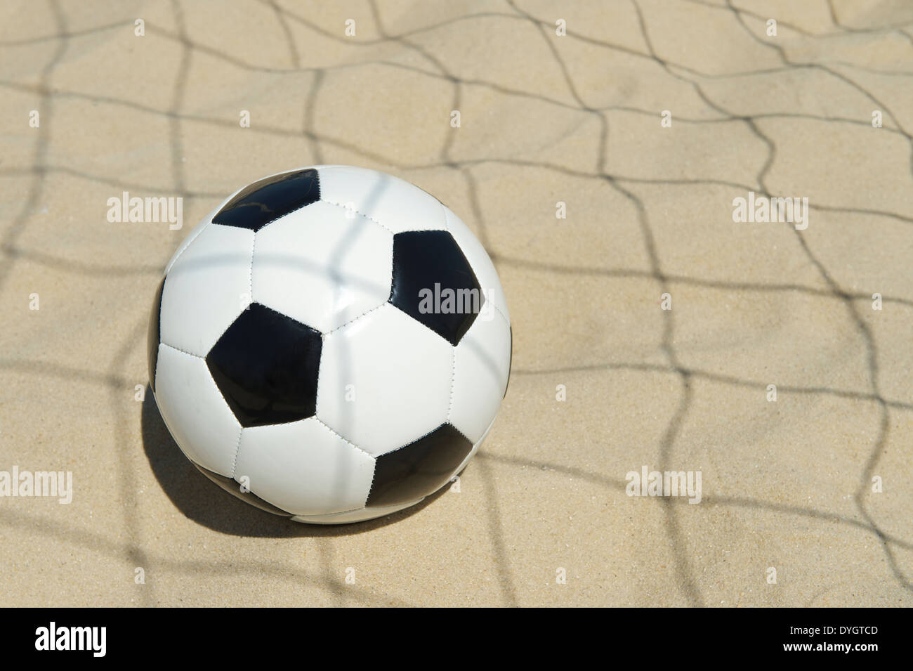Soccer goal ball in shadow of football net on the beach in Rio de Janeiro Brazil Stock Photo