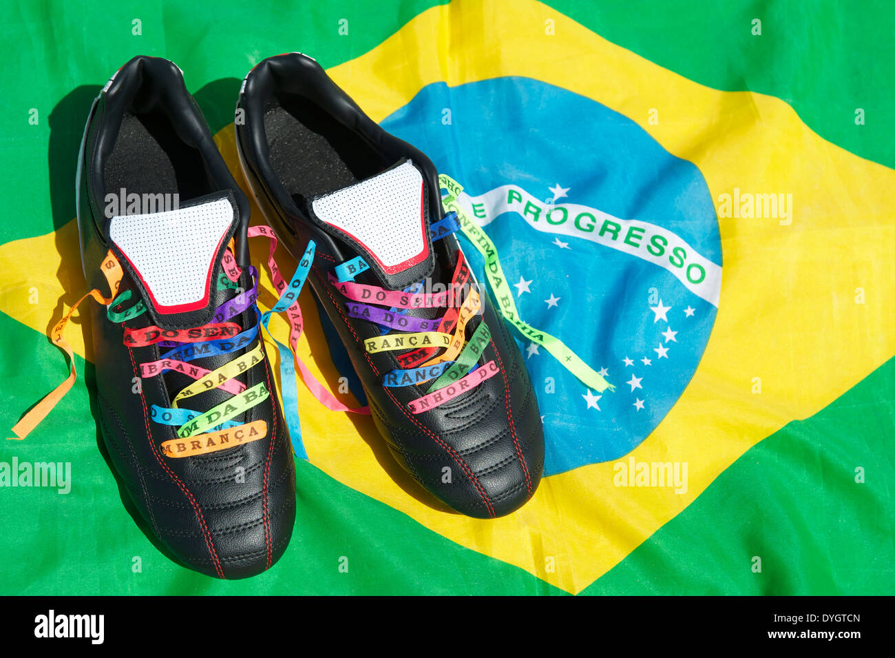 Good luck soccer football boots soccer cleats laced with Brazilian wish ribbons on Brazilian flag Stock Photo