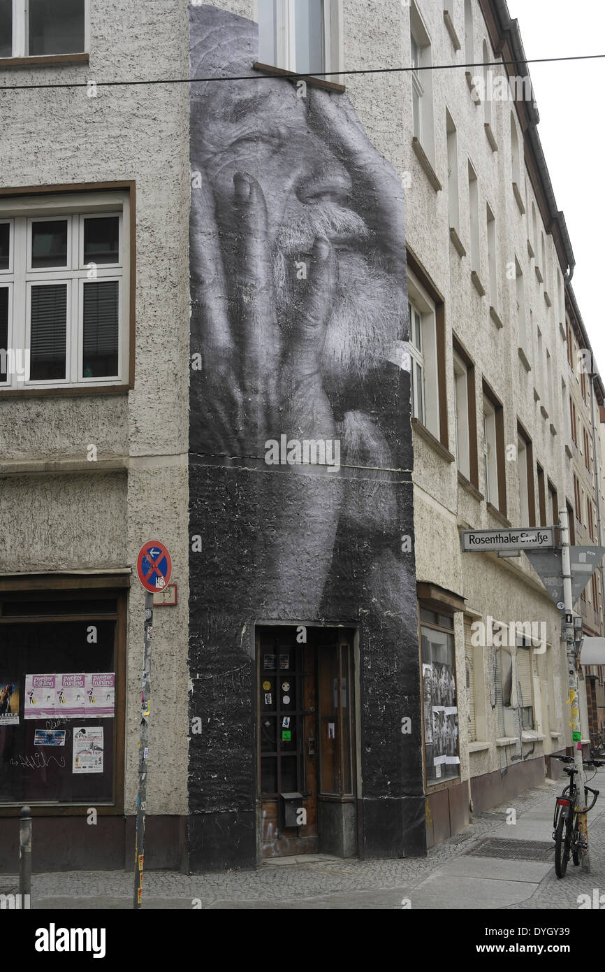 Wrinkles of the City Elderly Man Holding Head in Hands mural pasted corner building, Rosenthaler Strasse at Augustrasse, Berlin Stock Photo