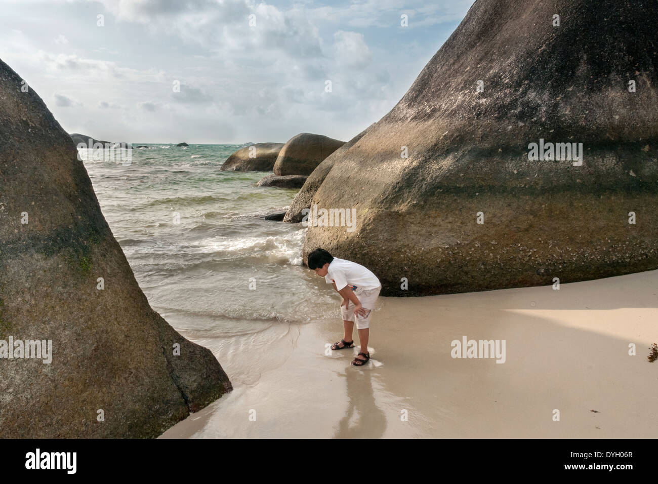 Boy looking for shells, Tanjung Tinggi beach, Belitung Island, Indonesia Stock Photo