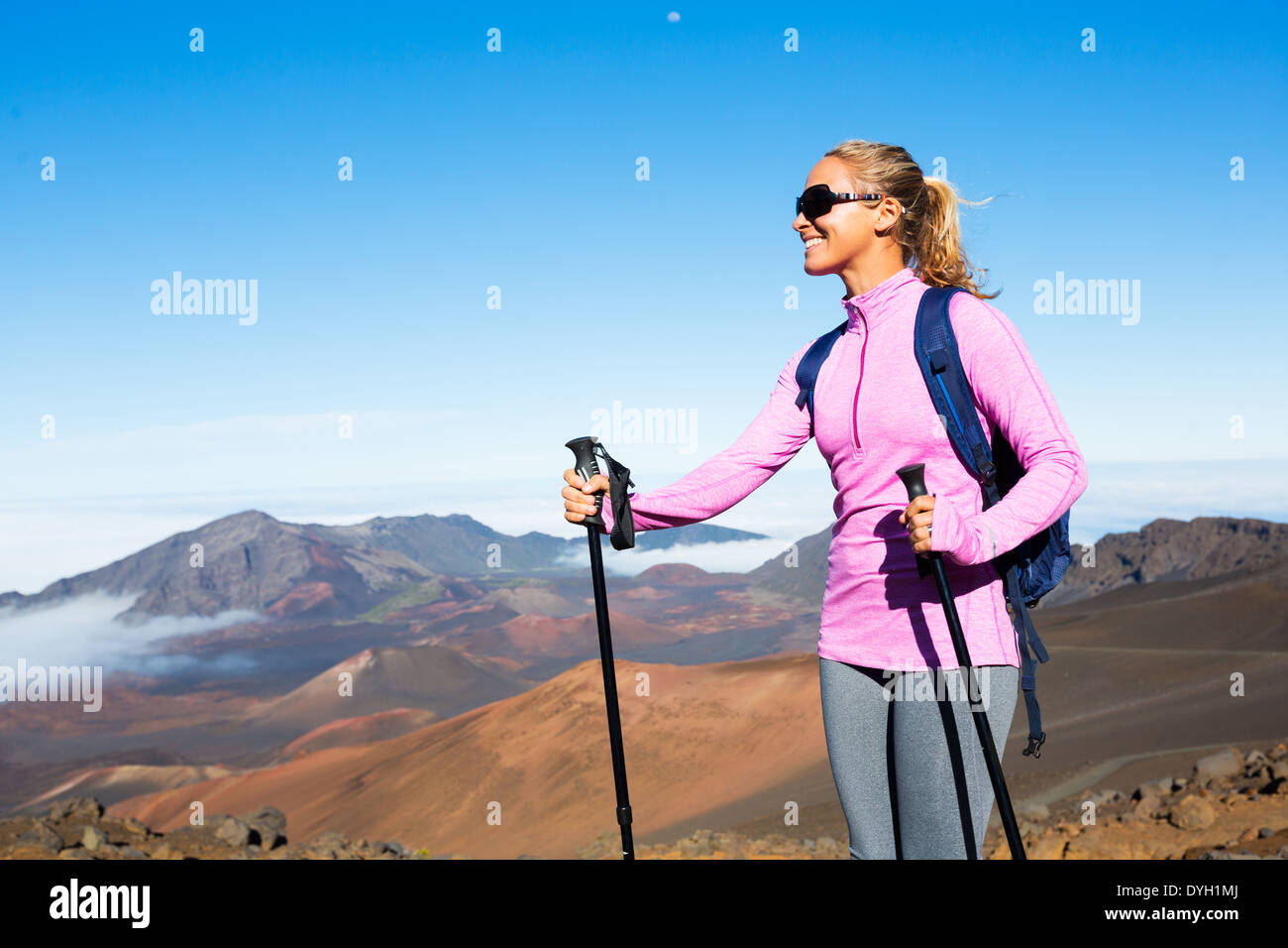 Female hiker with backpack standing on mountain top enjoying the view ...