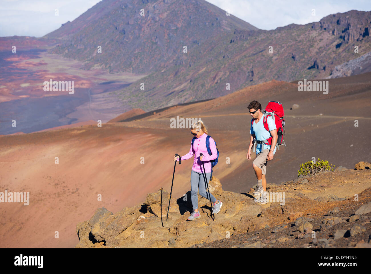 Hikers enjoying walk on amazing mountain trail. Backpacking in Haleakala volcano, incredible view. Couple trekking. Stock Photo