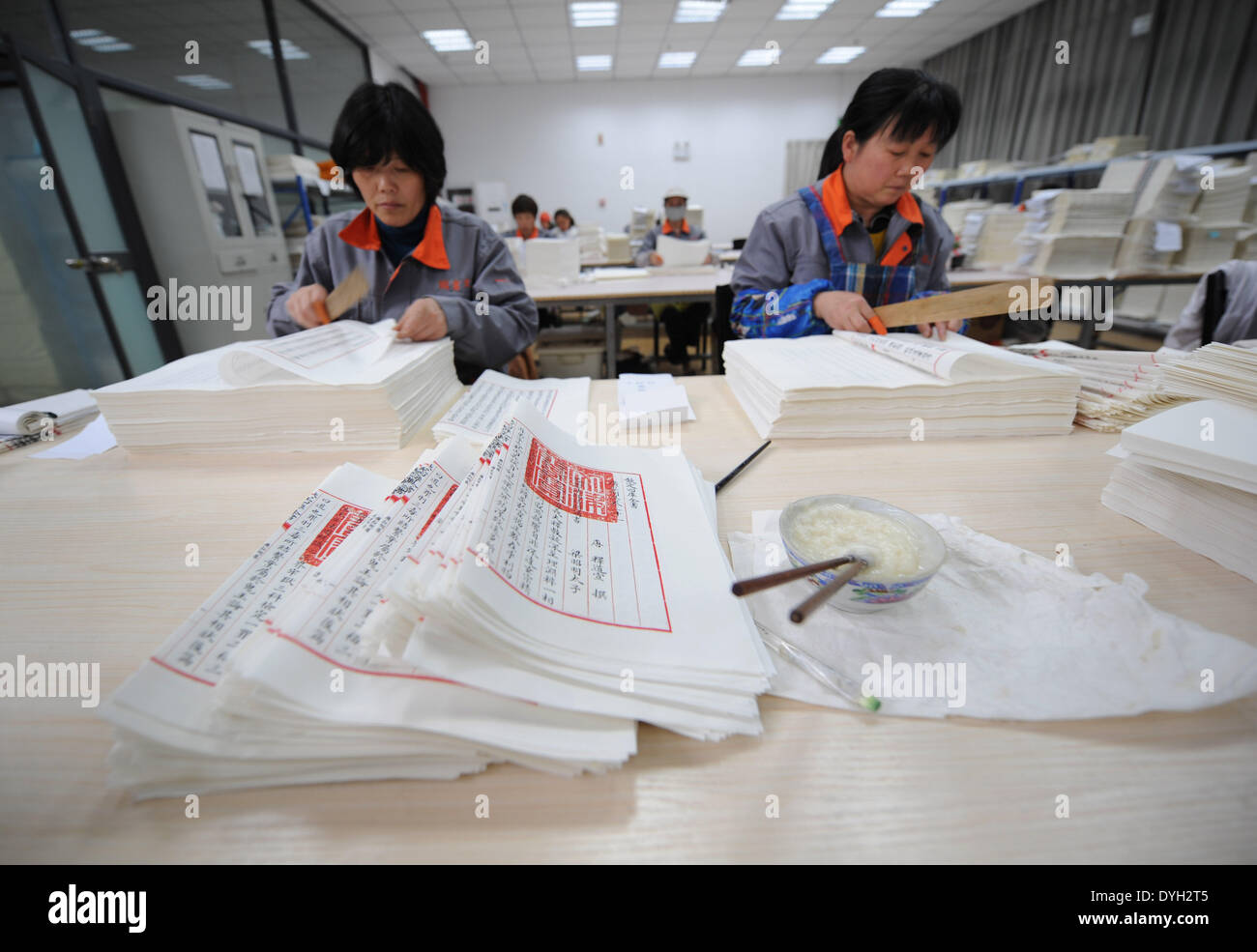 (140418) -- YANGZHOU, April 18, 2014 (Xinhua) -- Workers make the duplicate of a classic Chinese book, the 'Siku Quanshu,' or the 'Complete Library in the Four Branches of Literature,' in Yangzhou, east China's Jiangsu Province, April 16, 2014. The reproduction of the 'Siku Quanshu' will be on display in the Wanfo Building at Tianning Temple of Yangzhou starting from April 18. Compilation of the 'Siku Quanshu,' launched under the reign of Emperor Qianlong (1736-1795) in the Qing Dynasty (1644-1911) and organized by the literary emperor himself, took 15 years to complete. The Yangzhou copy of t Stock Photo