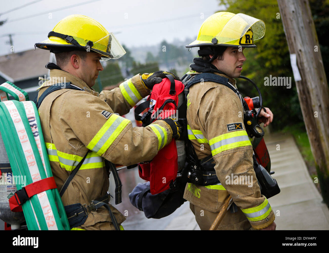 Vancouver, Canada. 17th Apr, 2014. Firefighters check with each other their equipments before entering a building during the fire and rescue exercise in city of Coquitlam, Canada, on April 17, 2014. Firefighters from city of Coquitlam's Fire department participated in an exercise at a vacant building to practice their techniques and responses in dealing with fires in high buildings. Credit:  Liang Sen/Xinhua/Alamy Live News Stock Photo