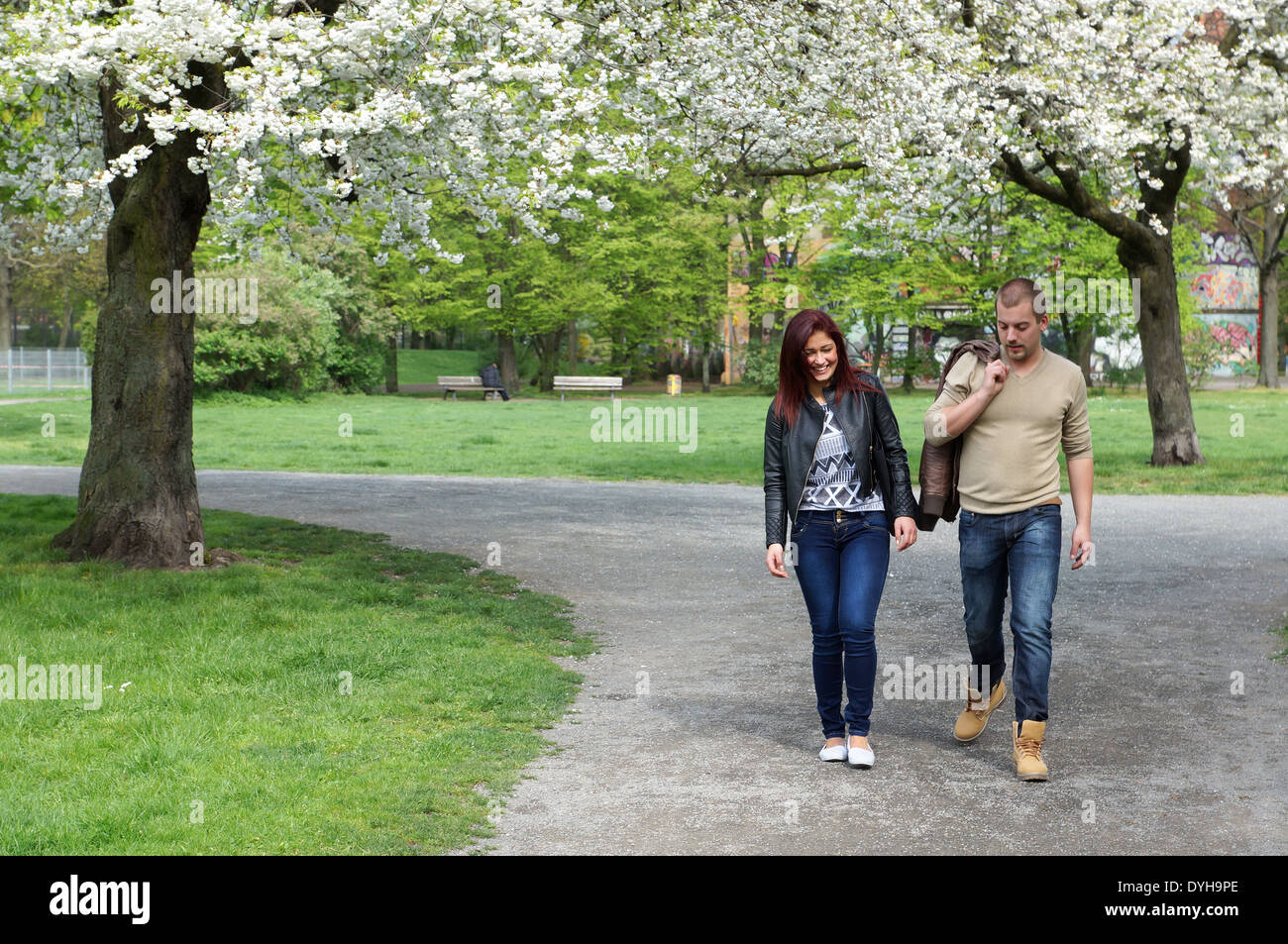 Young couple strolling through a park in spring Stock Photo