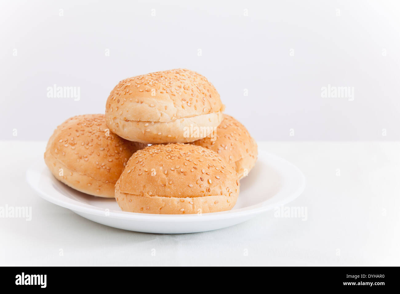 Small buns for hamburgers lay on white plate Stock Photo