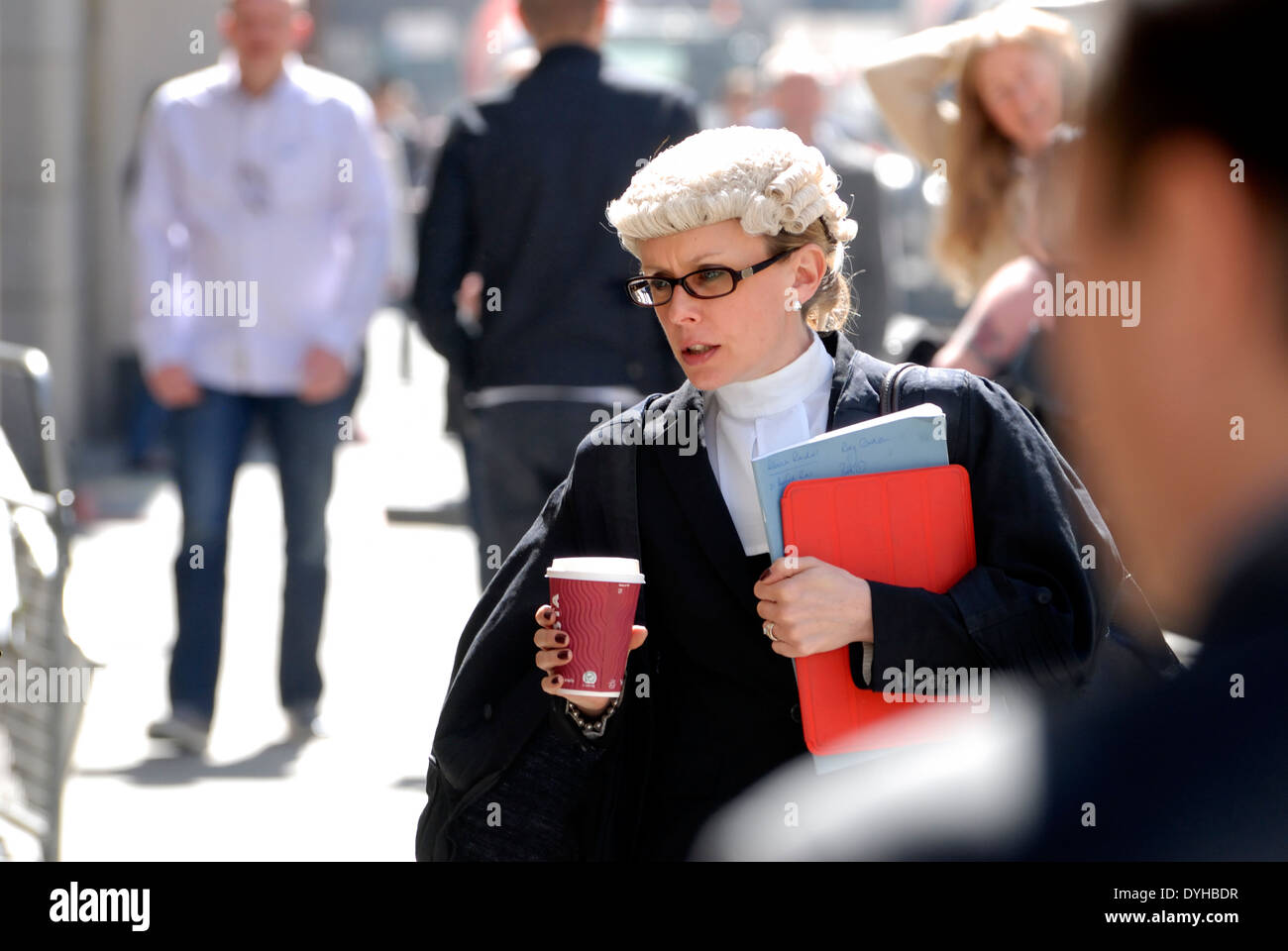 London, England, UK. Female barrister carrying a cup of coffee outside the Central Criminal Court, Old Bailey Stock Photo