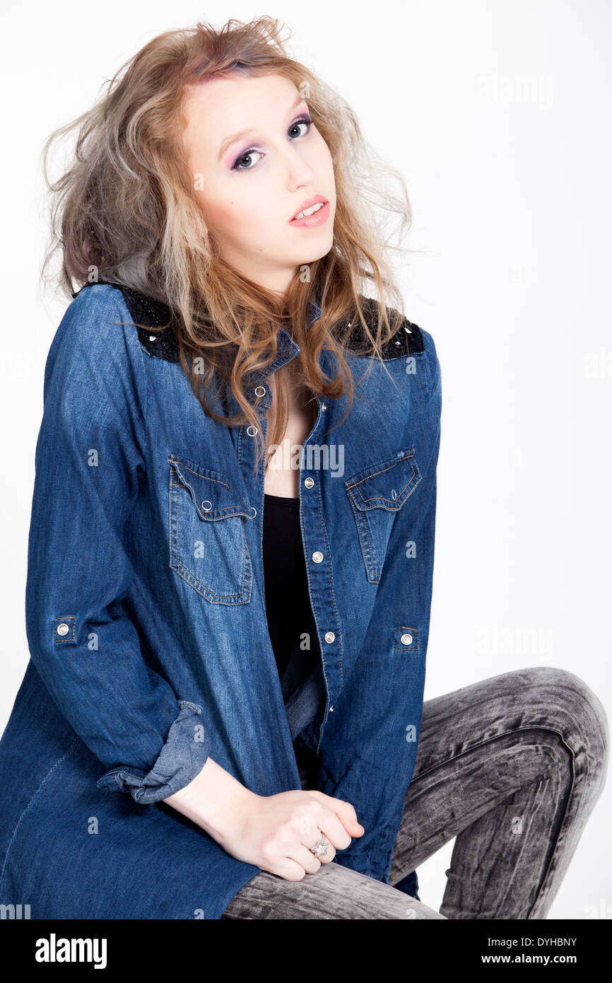 Young tough blond teenage girl with jeans blouse on a white background Stock Photo