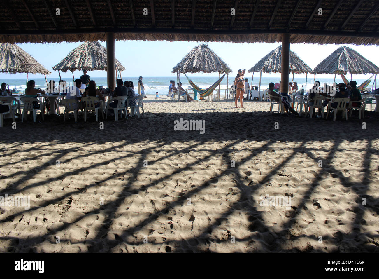 Shadows on sand along the beach front with palm-roofed shades and hammocks, Barra Vieja, Acapulco, Mexico Stock Photo