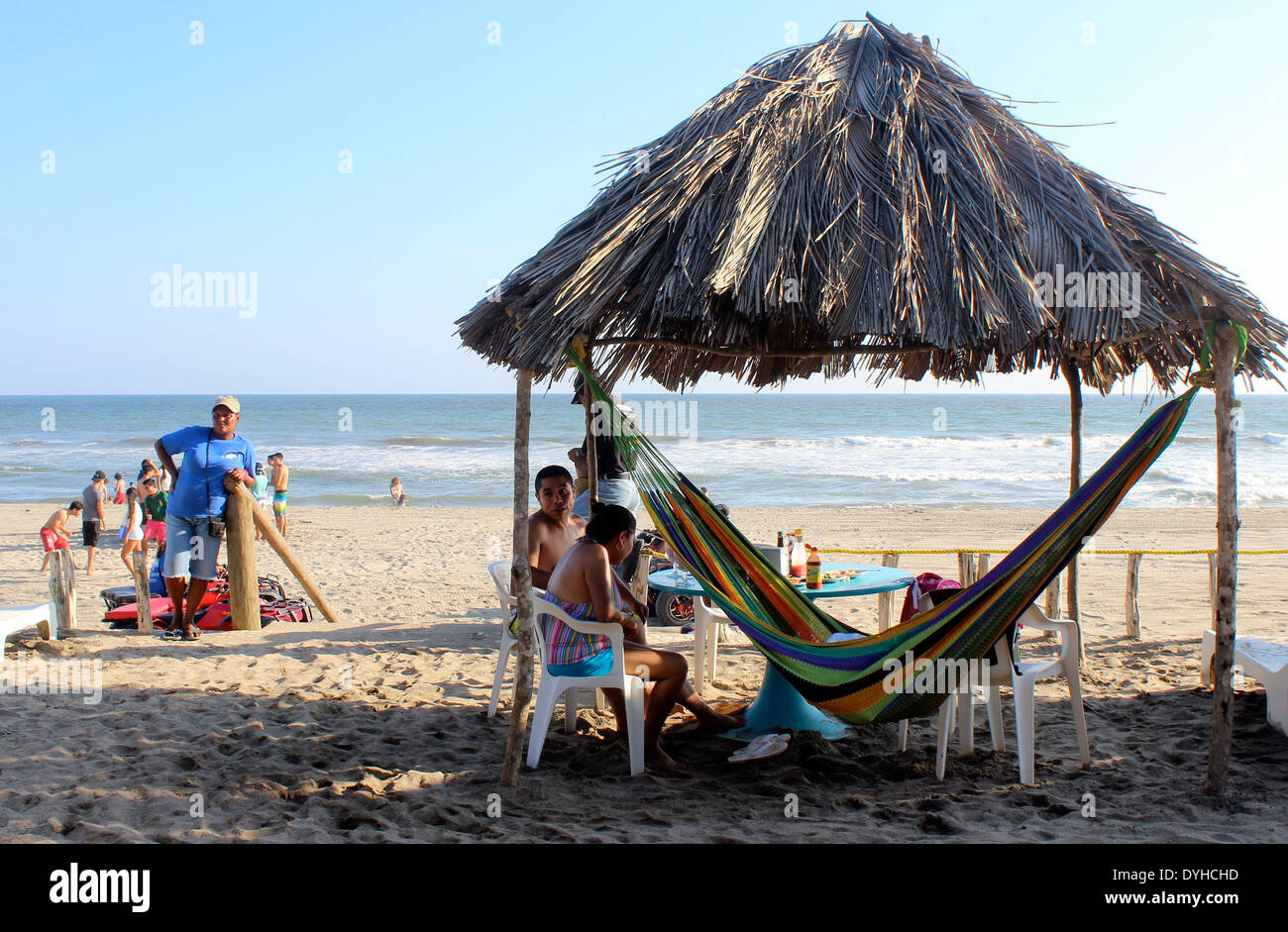 Palm roofed shade and hammock on the beach, Barra Vieja, Acapulco, Mexico Stock Photo