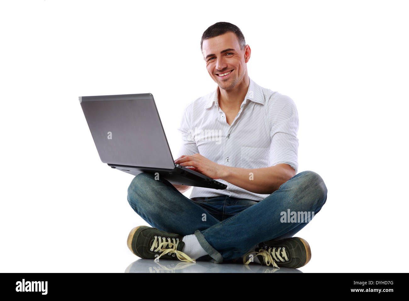 Happy man sitting at the floor with laptop over white background Stock ...