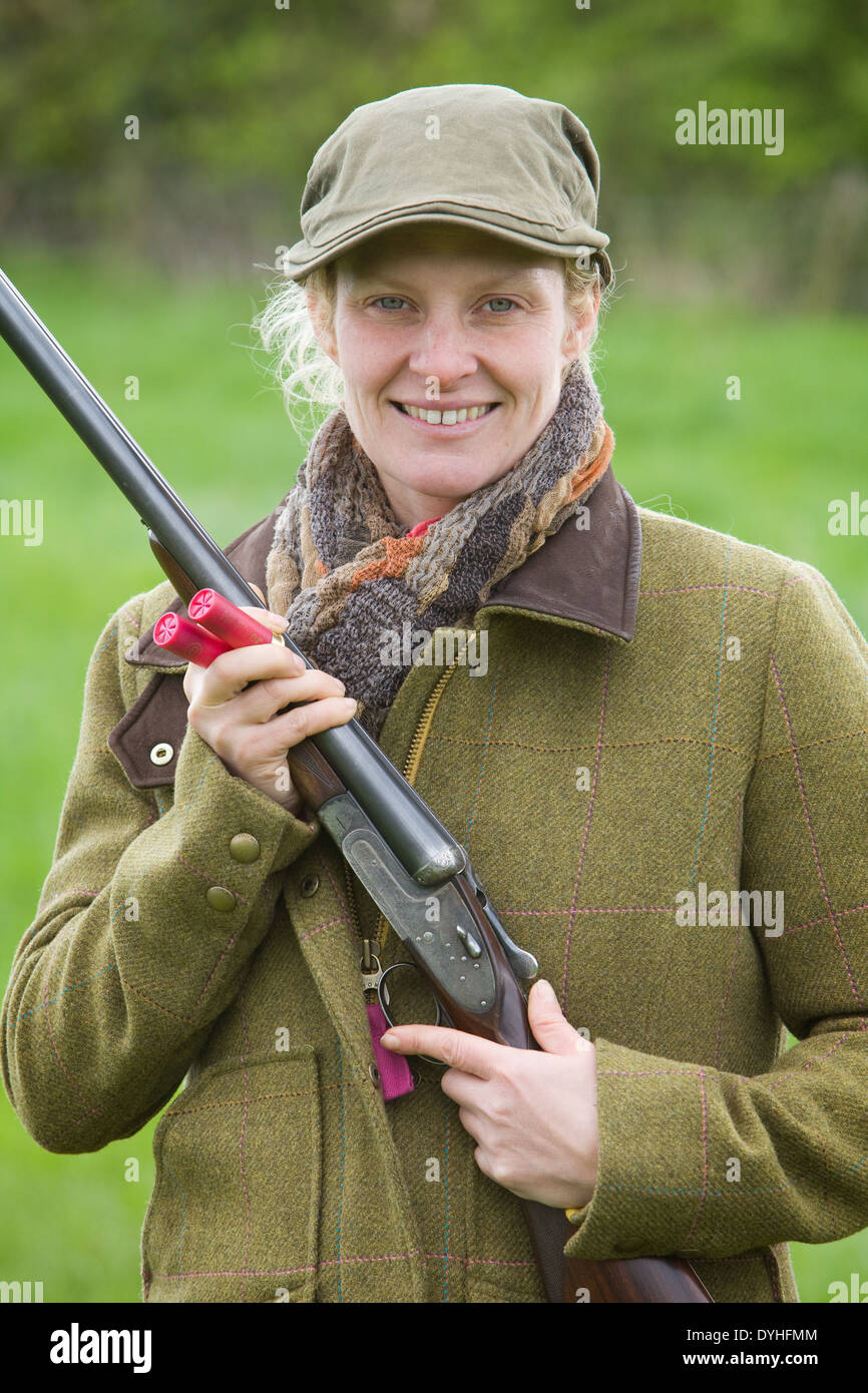 A woman wearing shooting clothing and standing outside in the English
