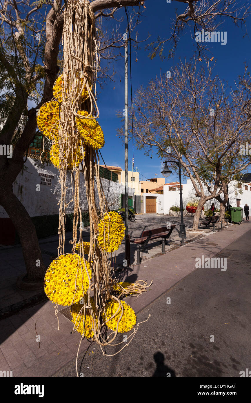 Floral and rope sculpture hanging from a tree in Guia de Isora, art as part of the Easter celebrations, Tenerife, Canary Islands, Spain Stock Photo
