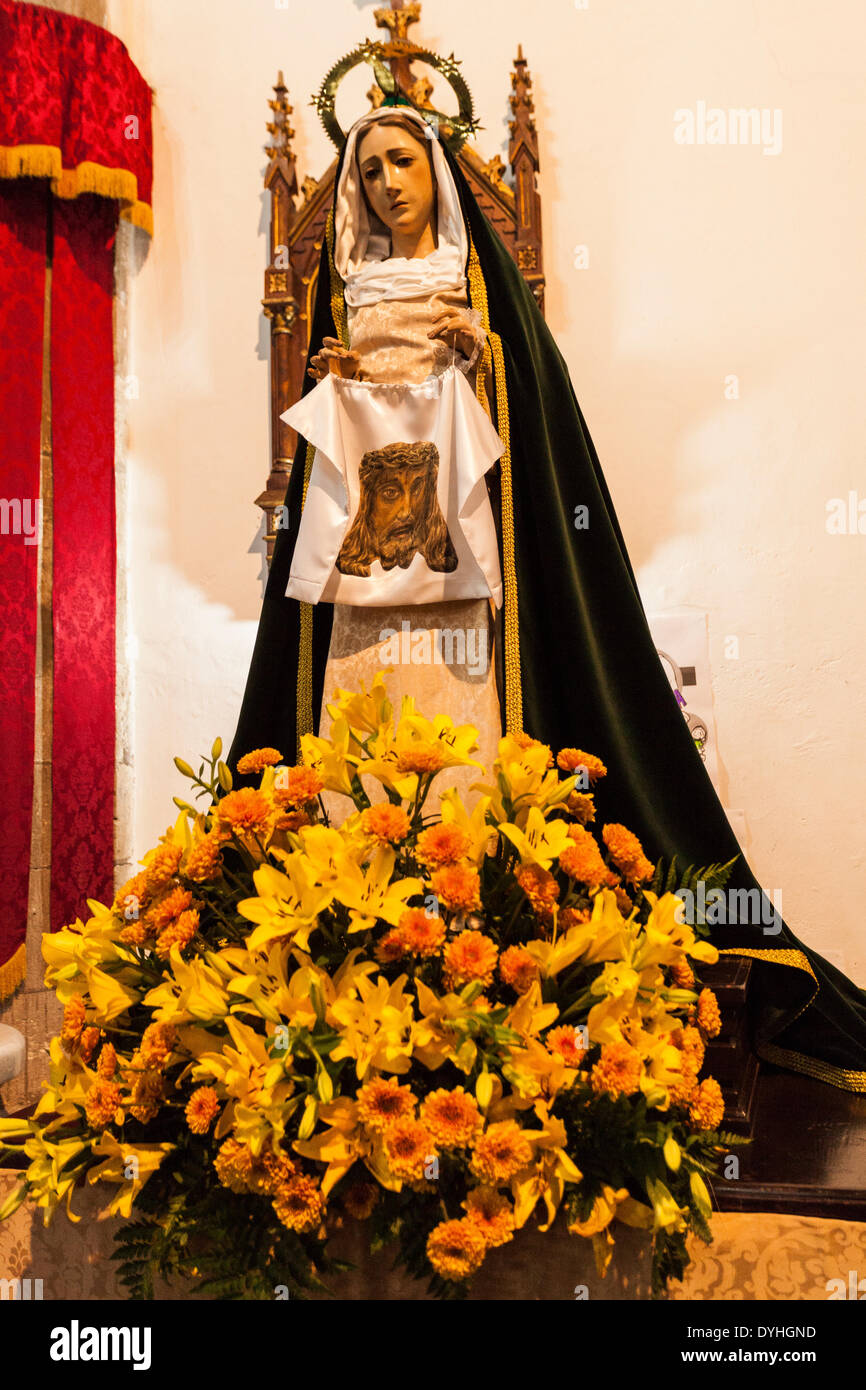Figure of the Madonna holding a cloth with the head of Jesus printed on it at Easter, decorated with flowers in a church in Guia de Isora, Tenerife, canary Islands Stock Photo