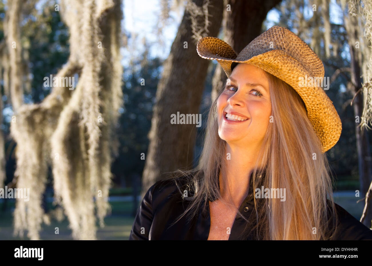 beautiful blonde middle aged woman cowgirl with cowboy hat on Stock Photo
