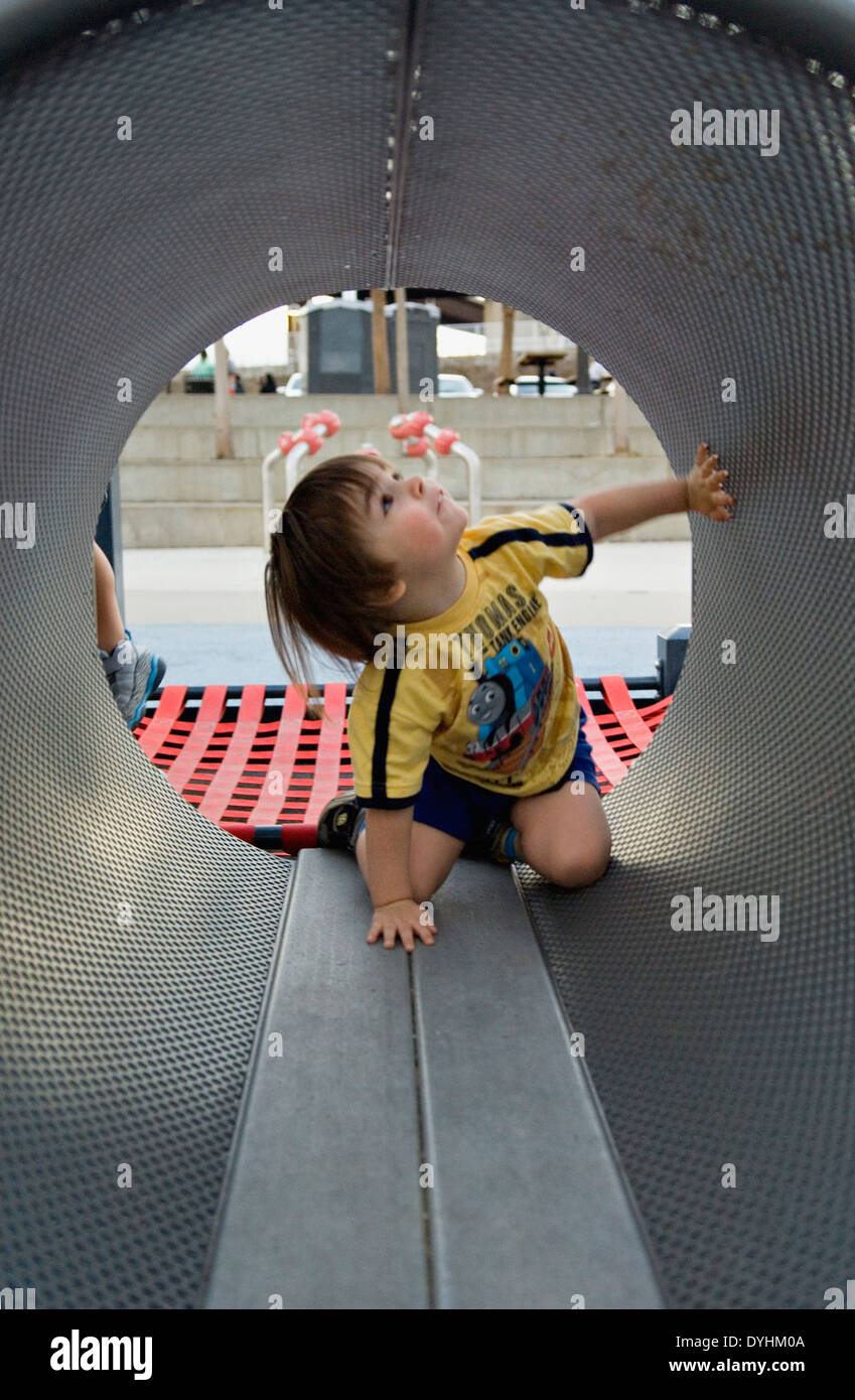 Toddler Playing in Tunnel on Playground at Waterfront Park in Louisville Kentucky Stock Photo