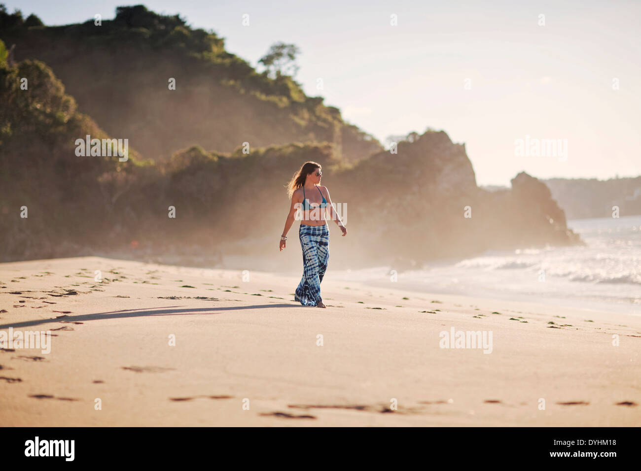 Young woman in bikini walking along the beach hi-res stock photography ...
