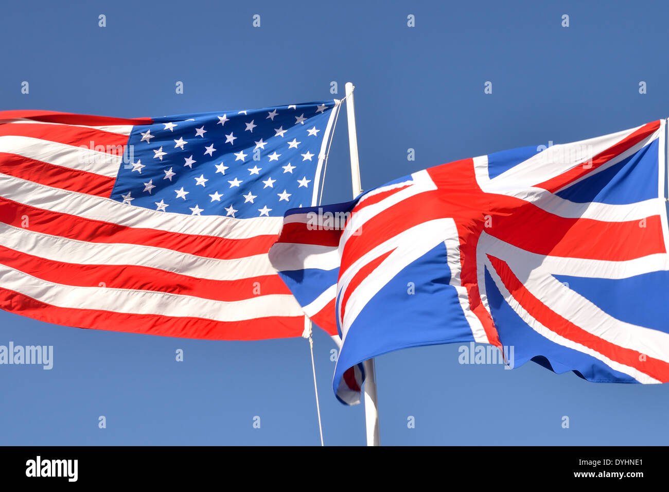 USA and UK flag against blue sky Stock Photo