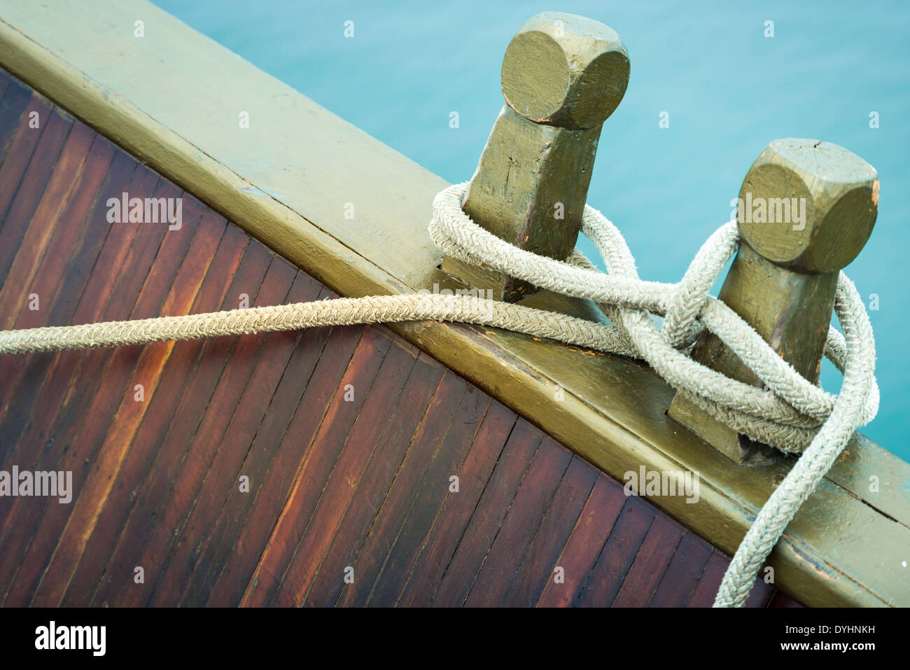 Marine rope tied into knot in foreground, white background. Closeup of nautical equipment for