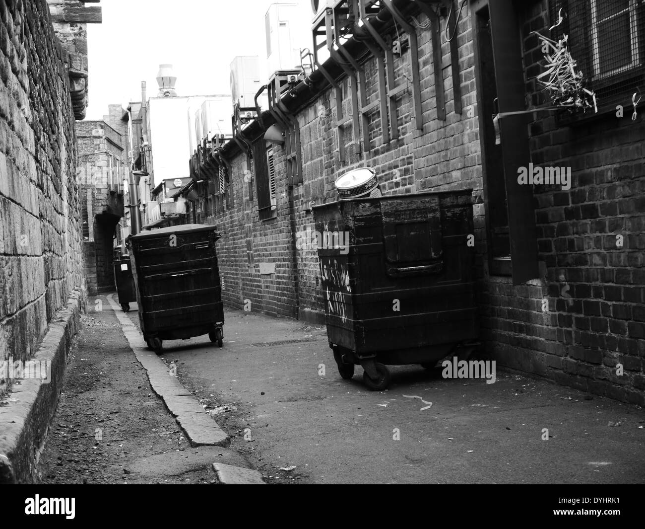 Monochrome image Urban street scene showing wheelie refuse bins near