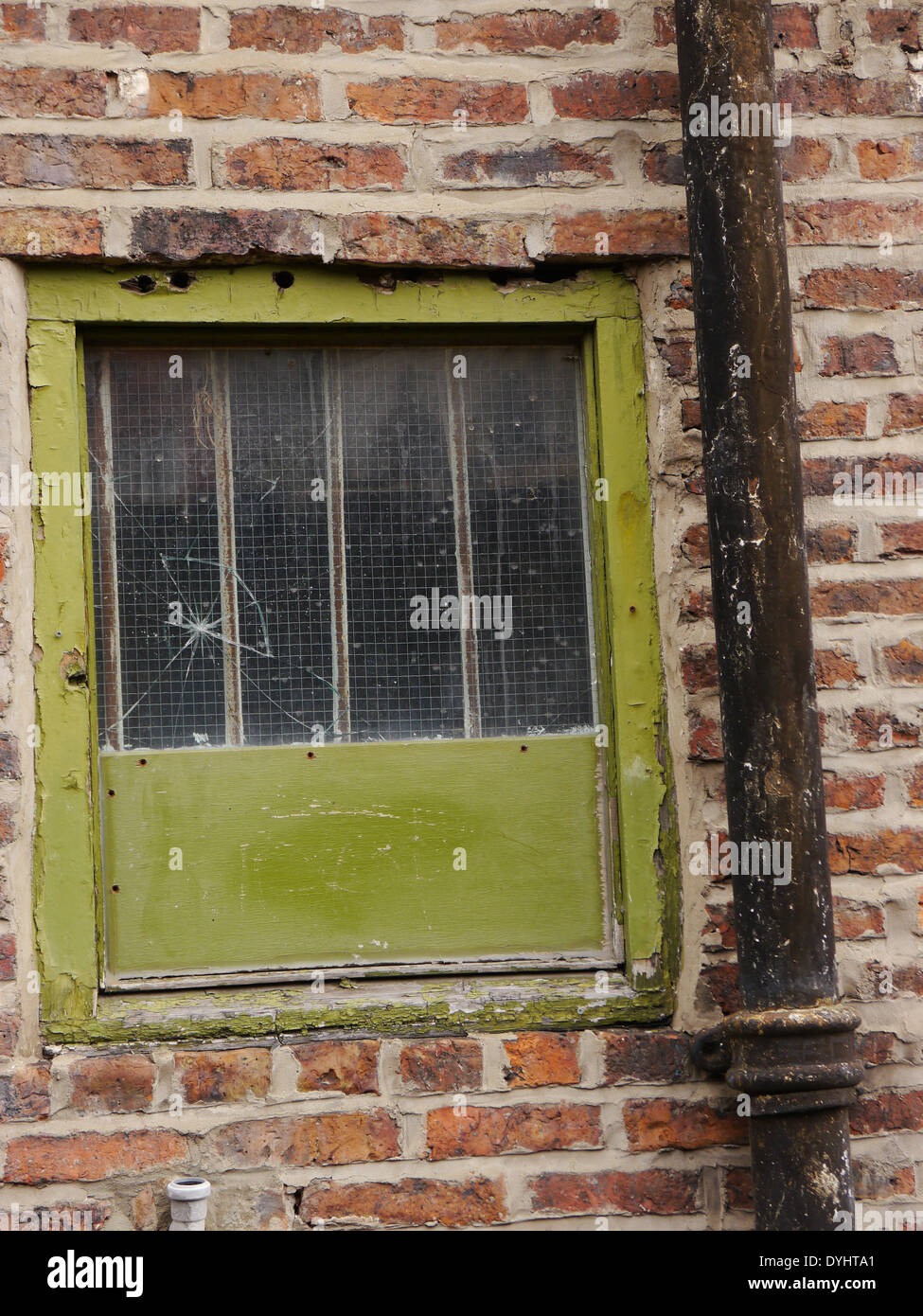 Derelict / abandoned / rundown property showing cracked window and downspout, Newcastle upon