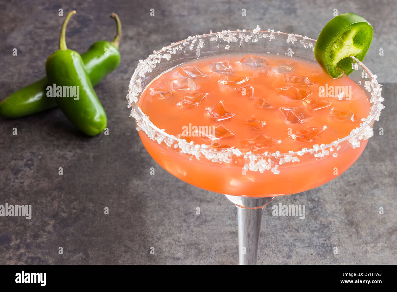 Spicy Hawaiian margarita made by soaking sliced jalapenos in guava