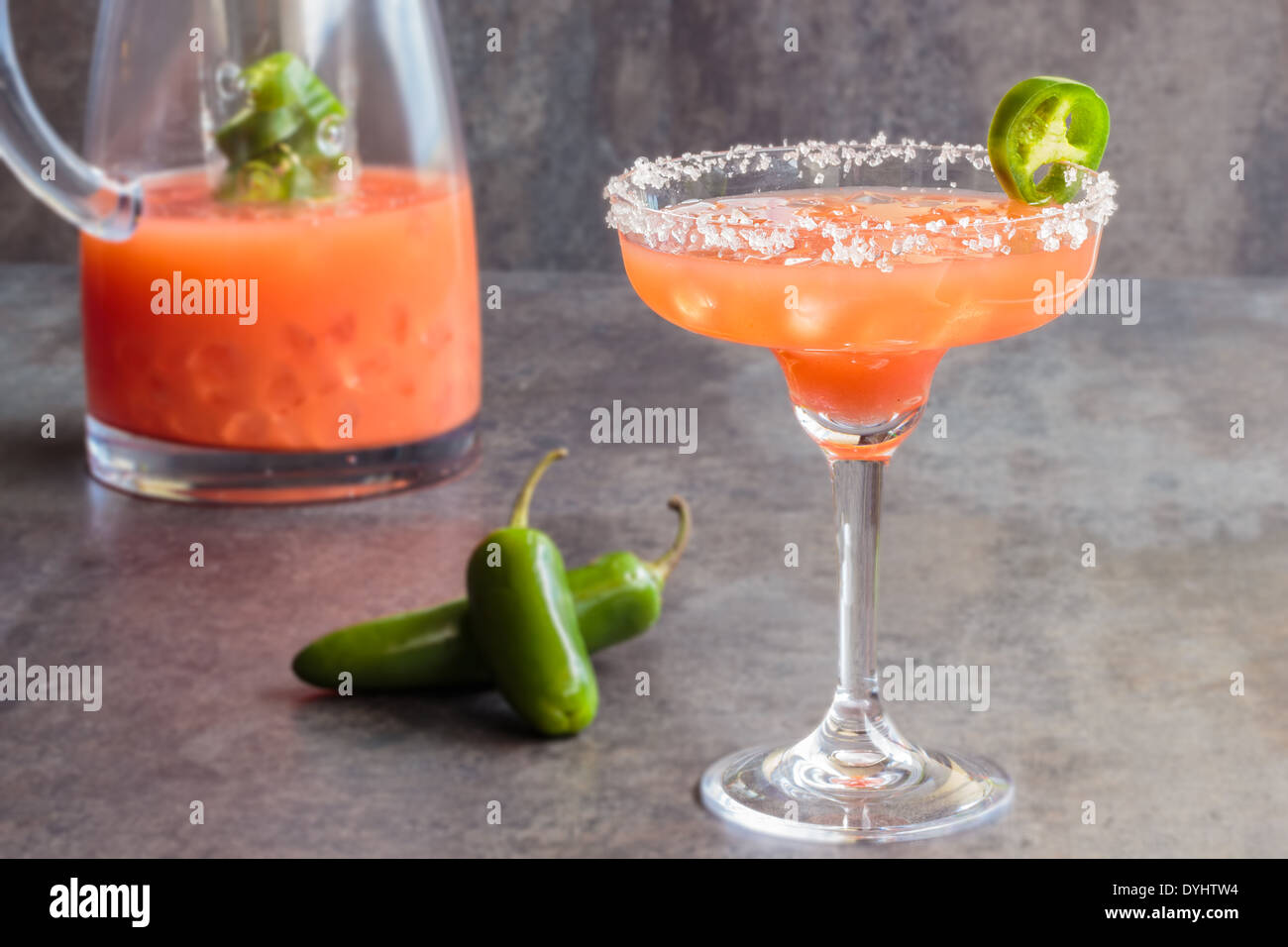 Spicy Hawaiian margarita made by soaking sliced jalapenos in guava