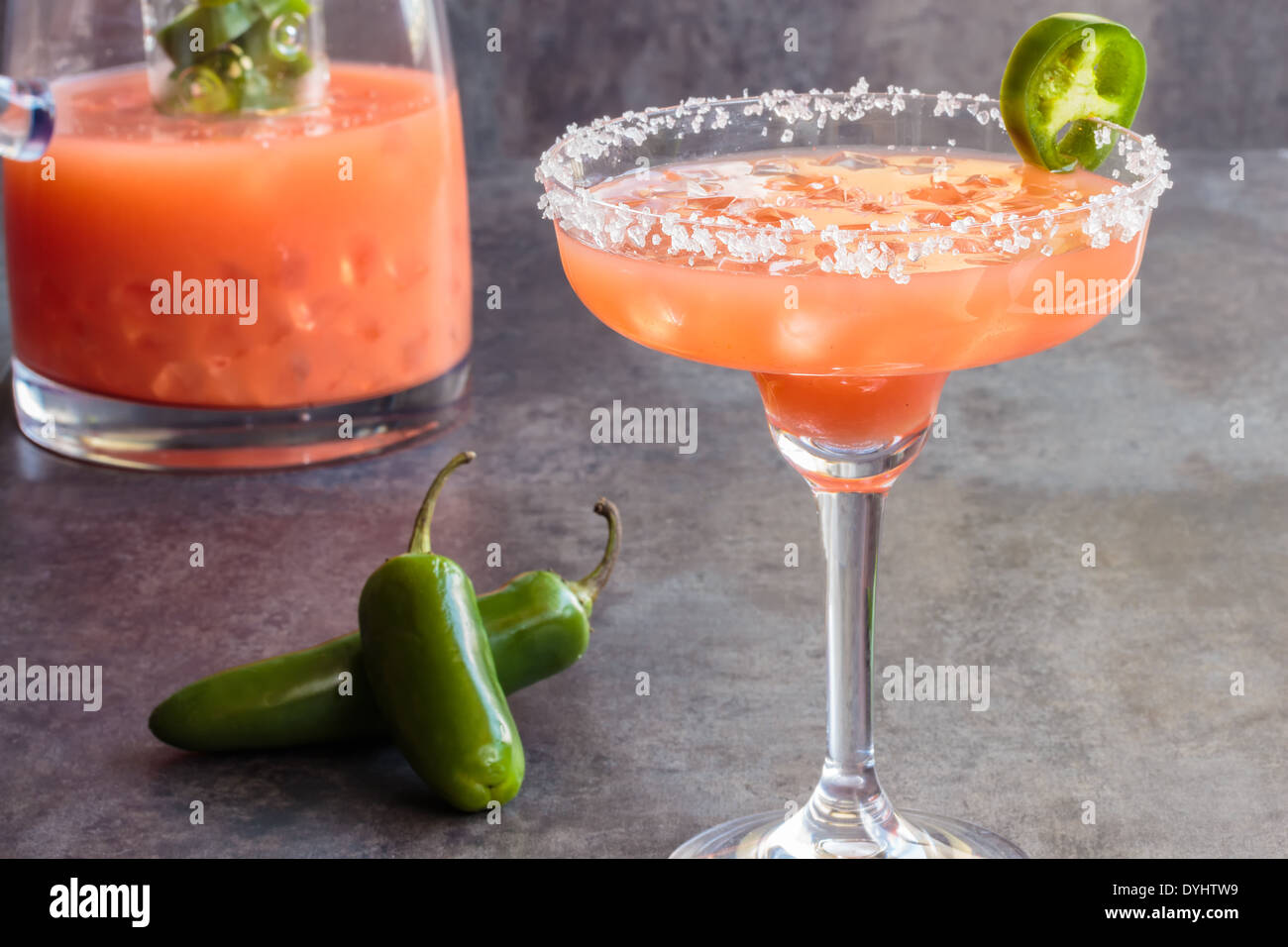 Spicy Hawaiian margarita made by soaking sliced jalapenos in guava
