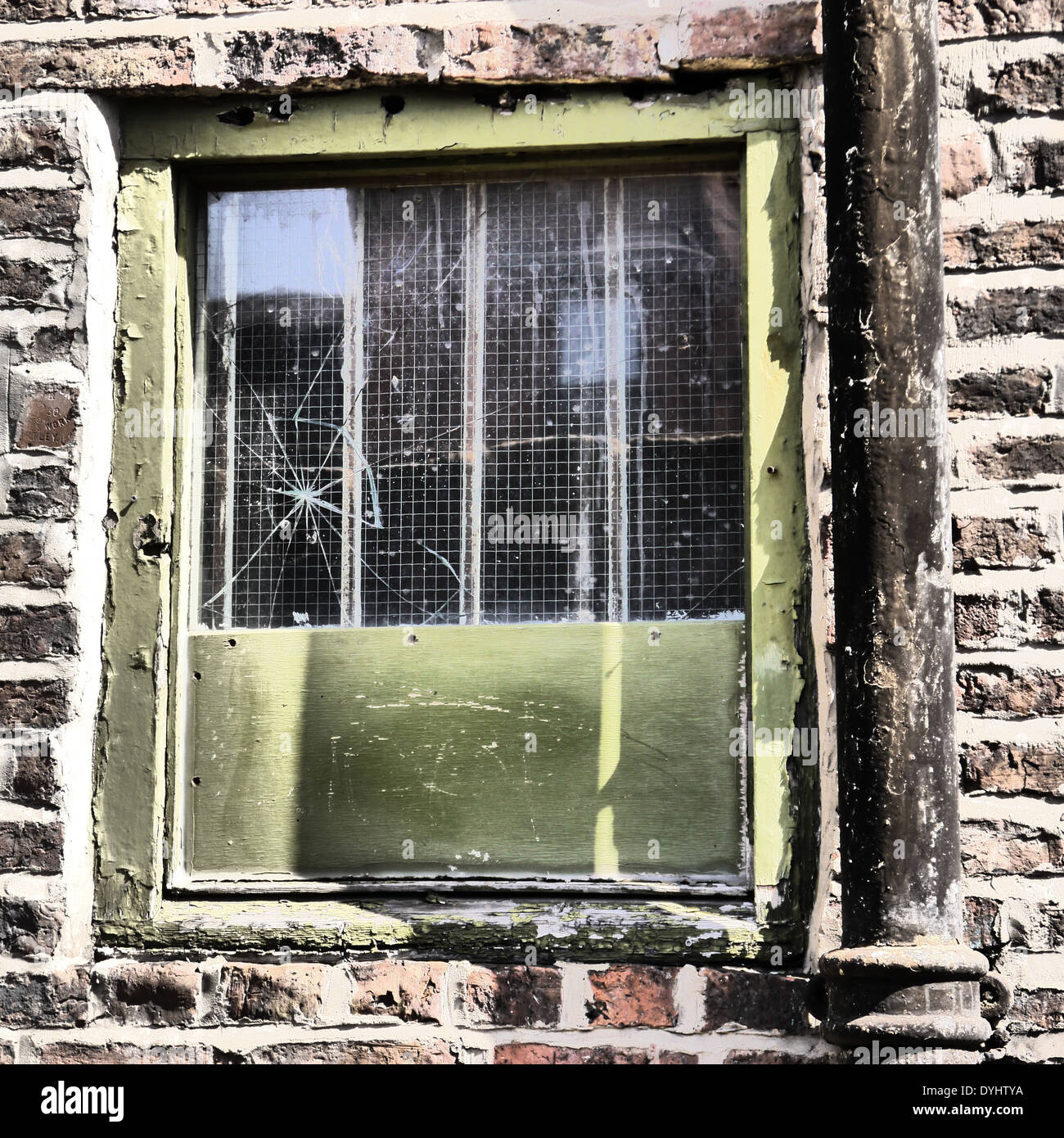 Derelict / abandoned / rundown property showing cracked window and downspout, Newcastle upon