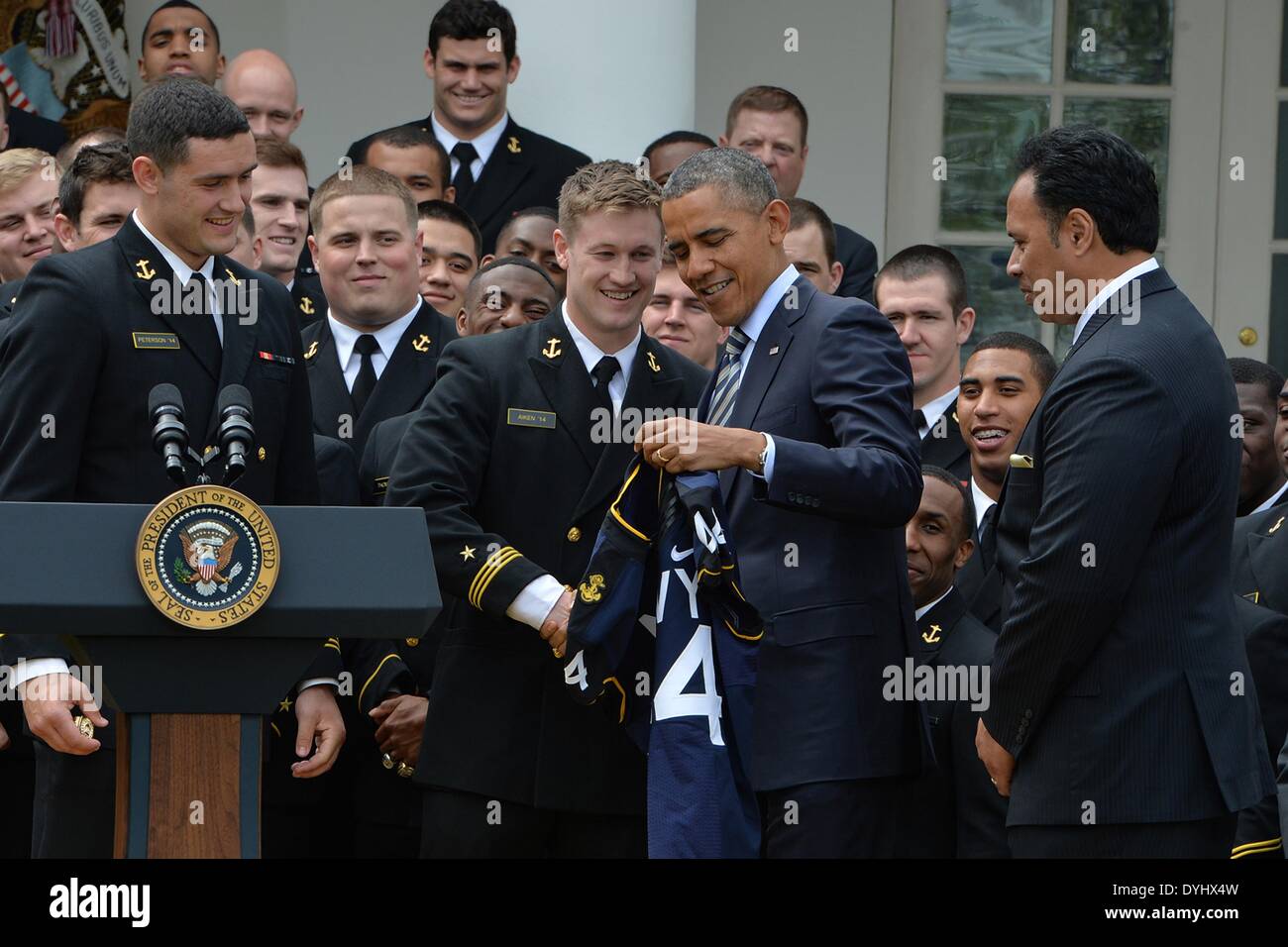 US President Barack Obama thanks US Naval Academy football team member Matt Aiken after being presented with a customized naval academy football jersey during an event on the South Lawn of the White House April 18, 2014 in Washington, D.C. The president presented the Navy Midshipmen with the Commander-in-Chief's Trophy, which goes to the Department of Defense academy team with the most victories against its Service rivals. Stock Photo