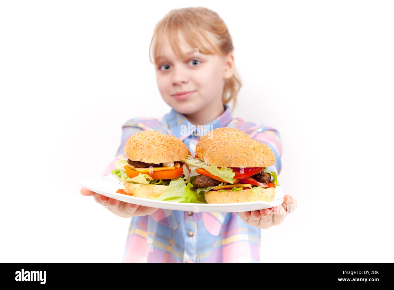 Little smiling blond girl with big homemade hamburgers on white plate Stock Photo