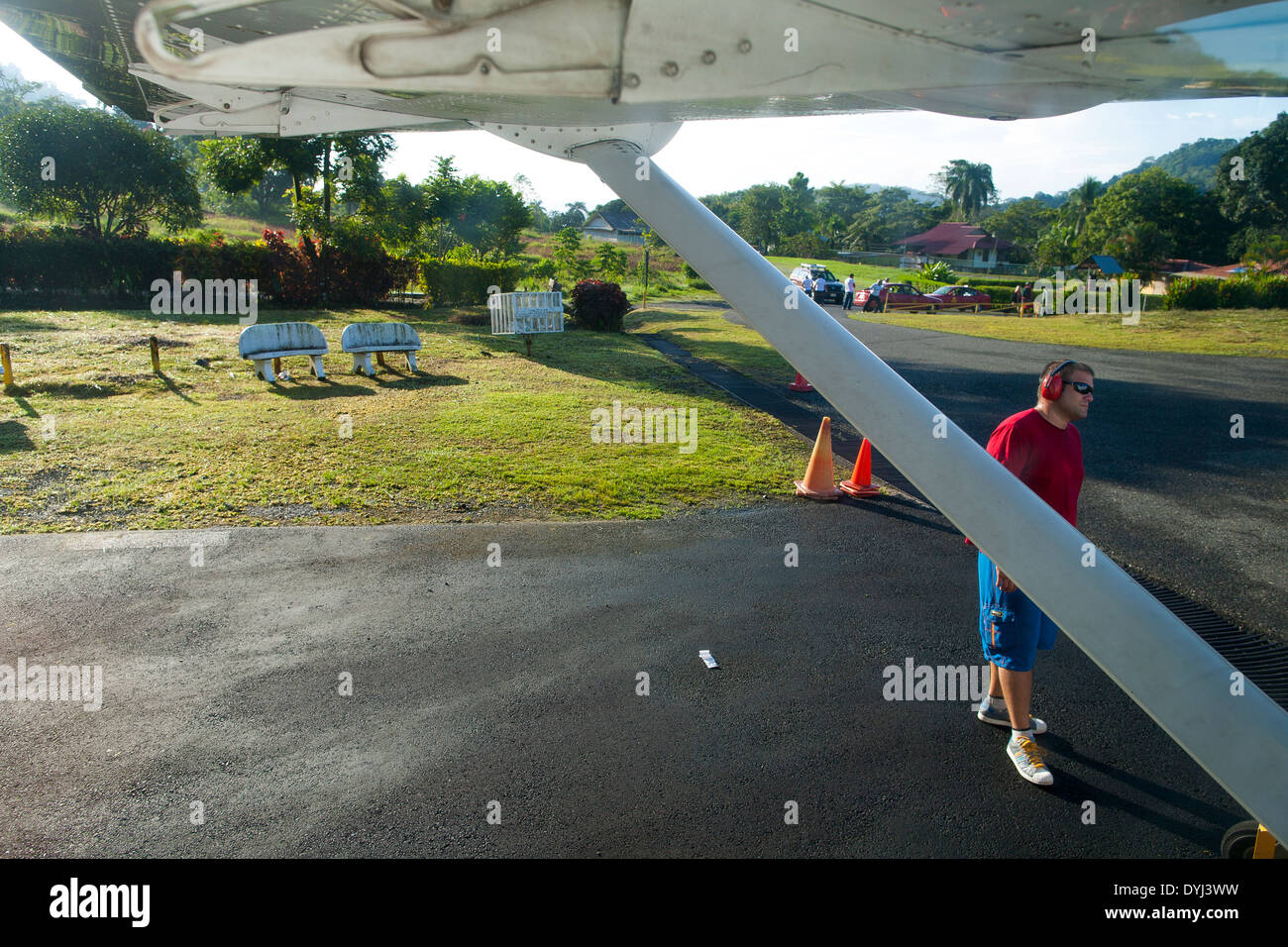 An airport worker prepares to guide a small plane onto the runway at Golfito Airport in Golfito, Costa Rica Stock Photo
