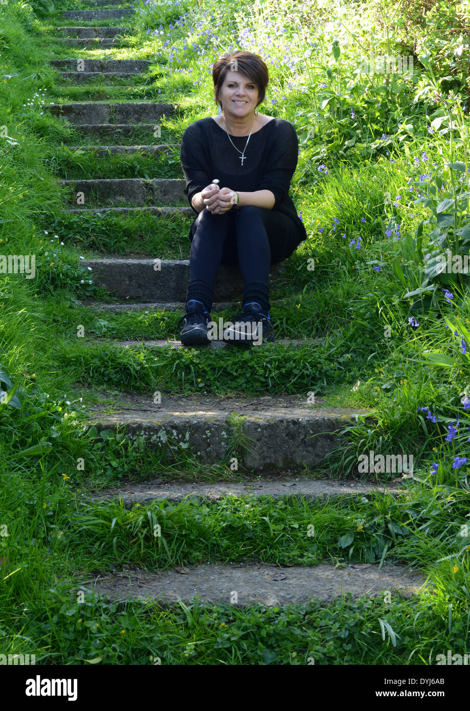 Woman sitting on steps cut into the hillside Stock Photo Alamy