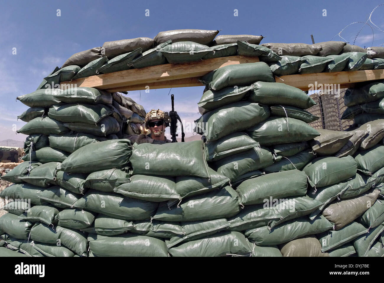 US Army Spc. Josh Lueken stands watch from a sandbagged bunker April 18, 2014 at Observation Post English, Logar province, Afghanistan. Stock Photo