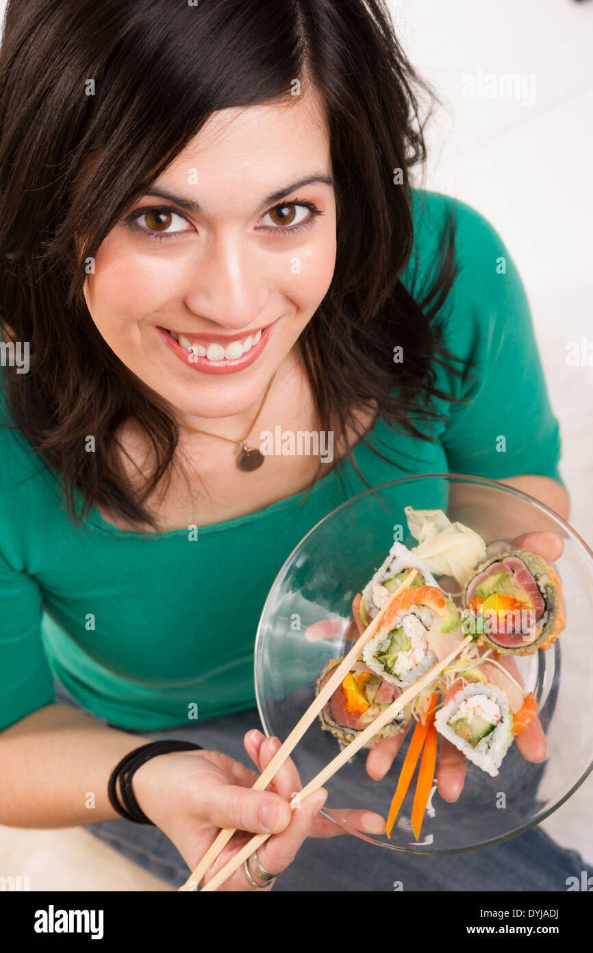 Adorable woman enjoys small raw food fish snack Stock Photo