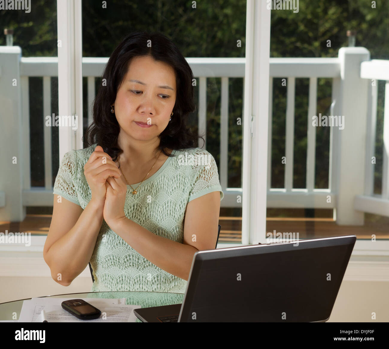 Photo of mature woman looking at computer screen while working at home ...
