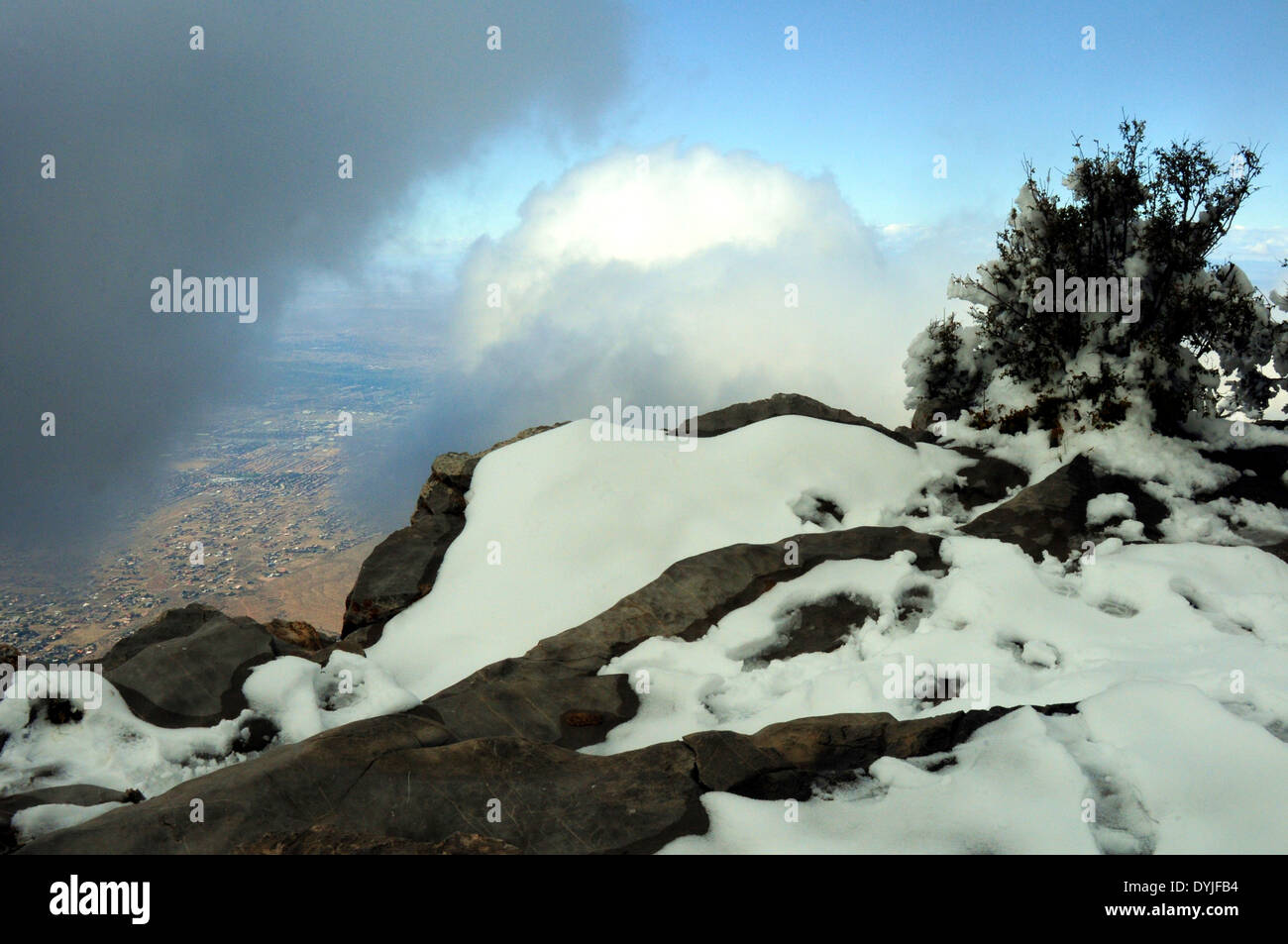 top of snow covered  Sandia Mtns  overlooking city below. Stock Photo