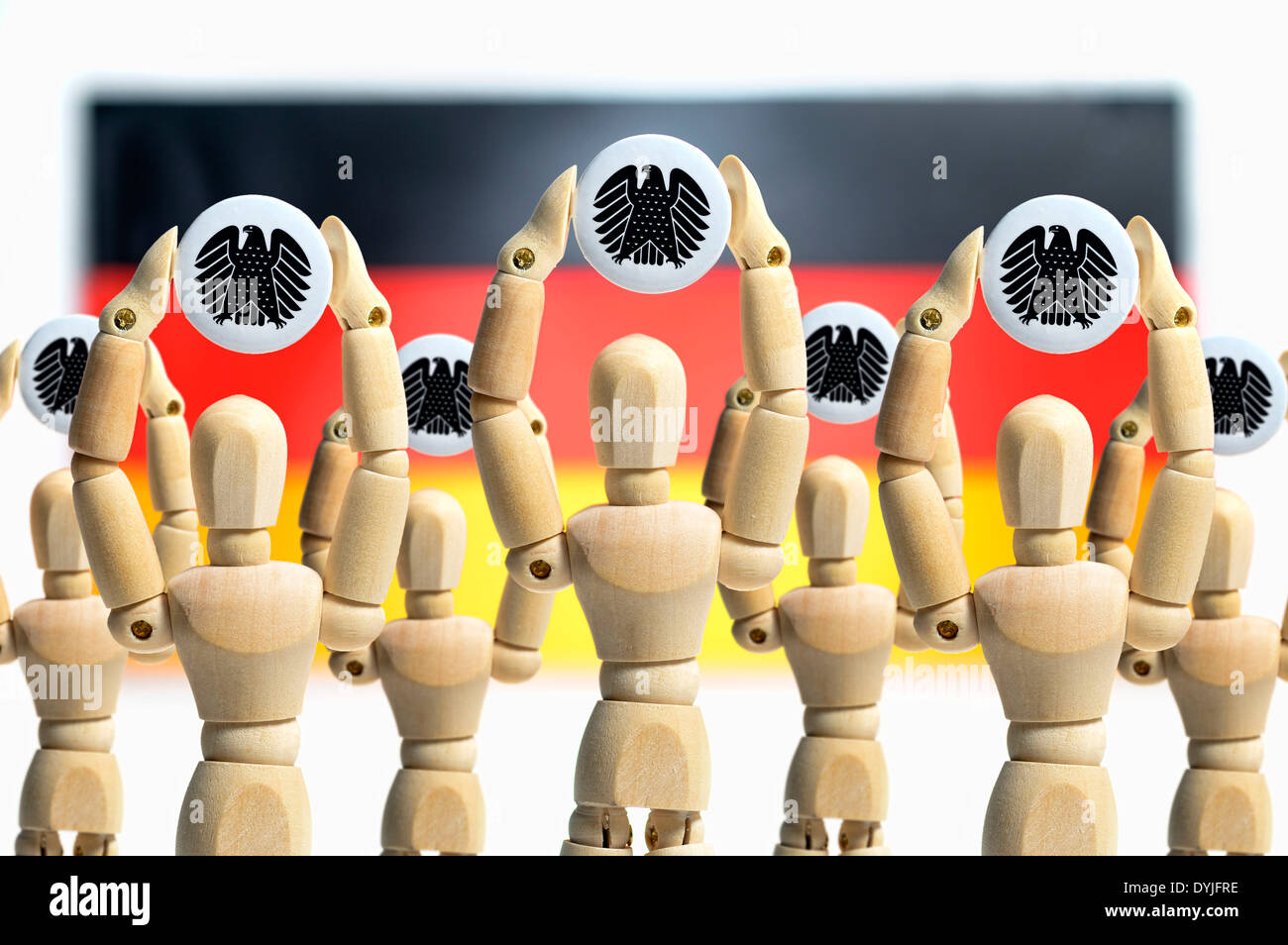 Holzfiguren halten Deutschen Bundesadler in die Höhe, Symbolfoto Volksentscheid Stock Photo