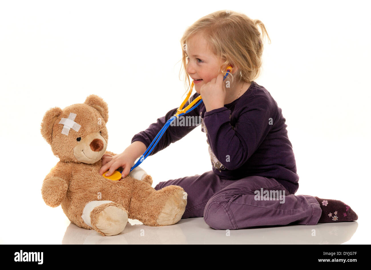 Kind mit Stethoskop als Arzt. Kinderarzt untersucht Patienten / Child with a stethoscope like a doctor. Pediatrician examined pa Stock Photo