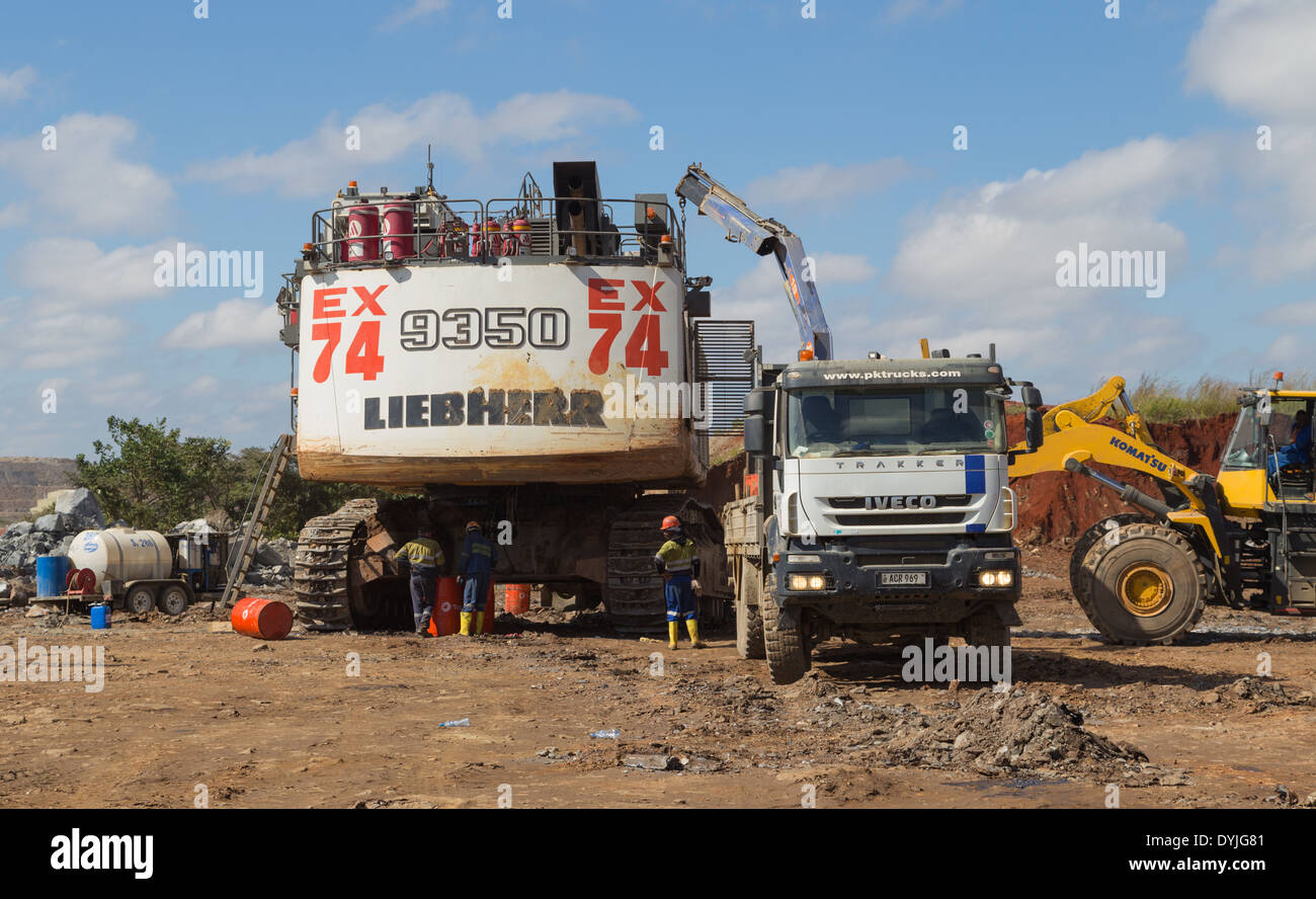 Mine workers service and repair a massive excavator in a large open