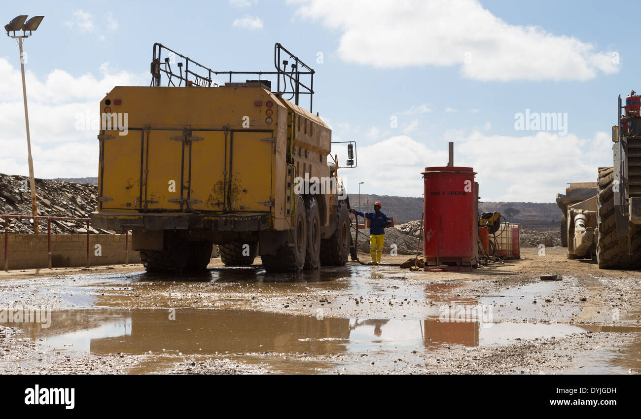 A truck operator refuells his diesel bowser in a large, open cast copper mine in Zambia. Stock Photo