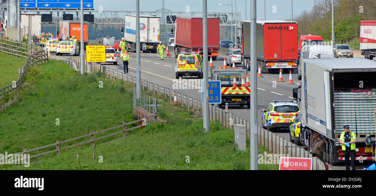 Police at what is believed to be 2 incidents one distant & lorry  contents checked with people sitting on crash barrier Stock Photo