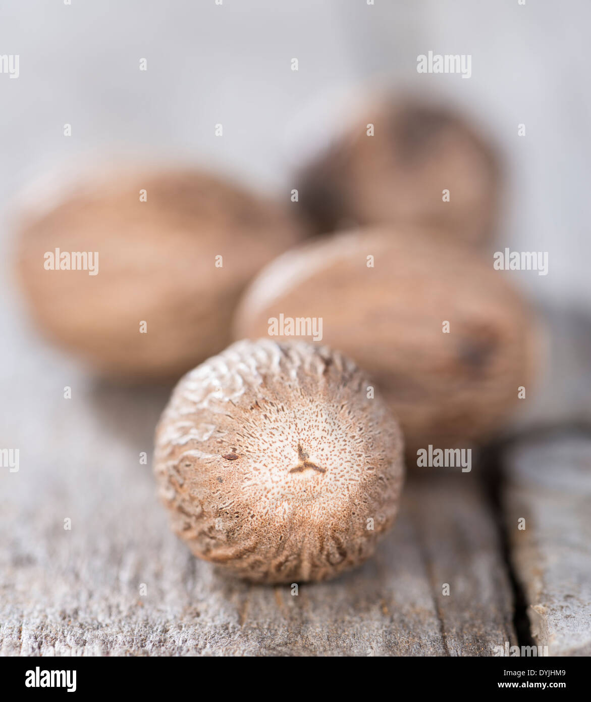 Some Nutmegs (close-up shot) on vintage background Stock Photo